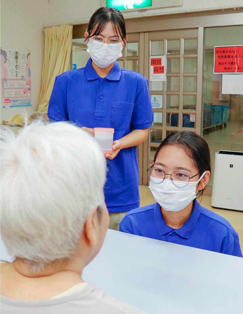 介護福祉士を目指し、特別養護老人ホームの現場で先輩職員から技術を学ぶミャンマー出身の留学生2名